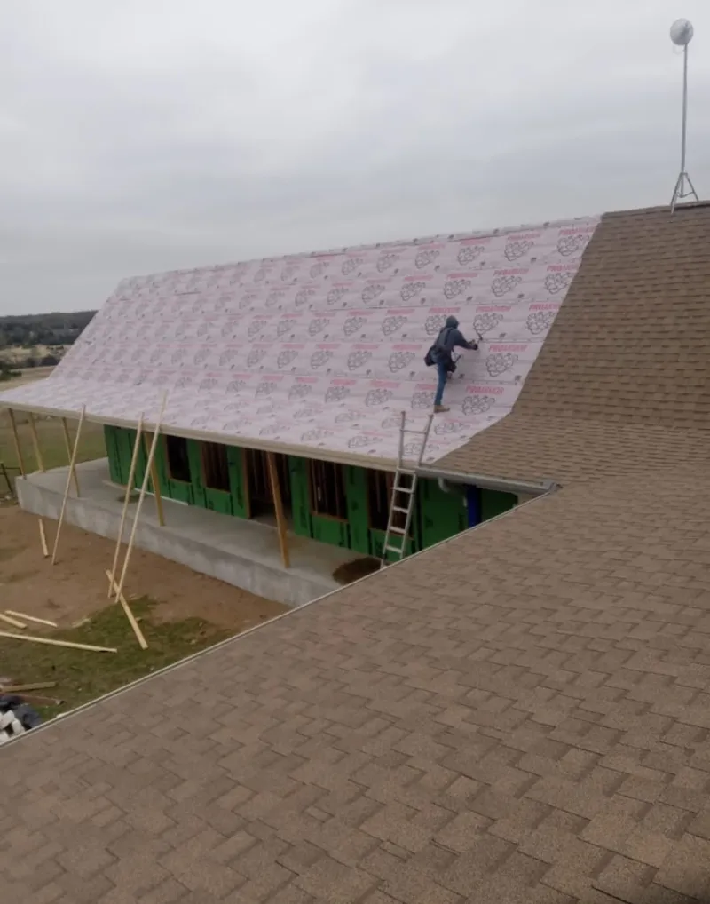 Worker preparing underlayment for a metal roof installation in Desert Hot Springs